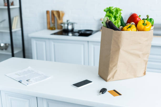 istock grocery bag, smartphone, newspaper, key and credit card on kitchen table 999096770