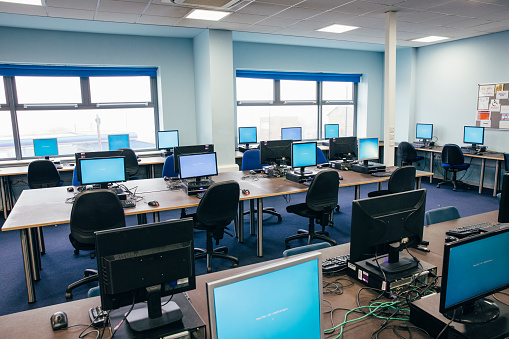 An engineering classroom can be seen with no people present. There are rows of desktop computers in the room ready for students to use.
