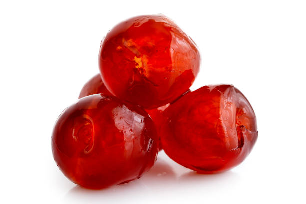 Closeup of four red glace cherries isolated on white. Closeup of four red glace cherries isolated on white. candied fruit stock pictures, royalty-free photos & images