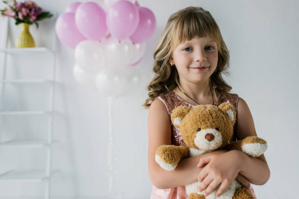 istock happy child looking at camera and embracing teddy bear 999098304