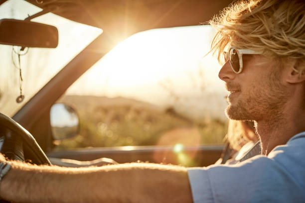 istock Man on road trip driving van during sunset 999098430