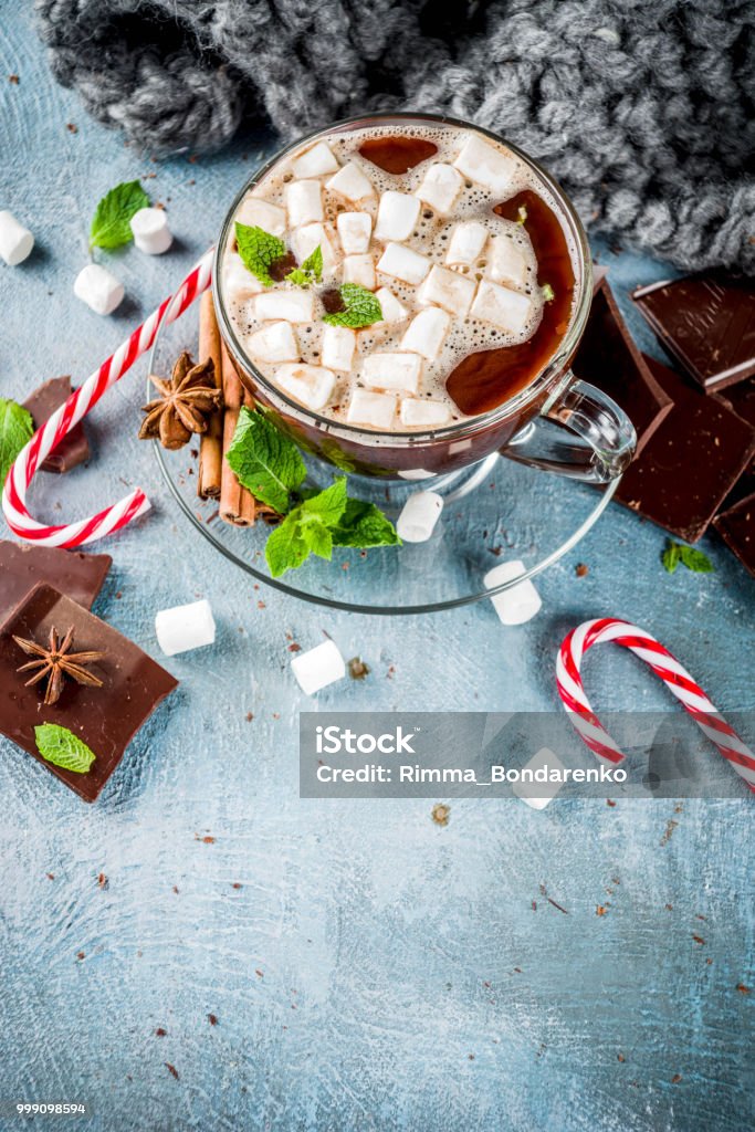 Hot chocolate with mint and marshmallow Homemade hot chocolate with mint, candy cane and marshmallow, light blue background with warm blanket, copy space Hazelnut Stock Photo