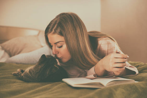 istock Leisure time with book and cat 999122382