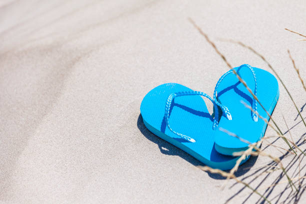 istock Summer, beach or holiday backgrounds: blue flip flops a white sand dune 999123162