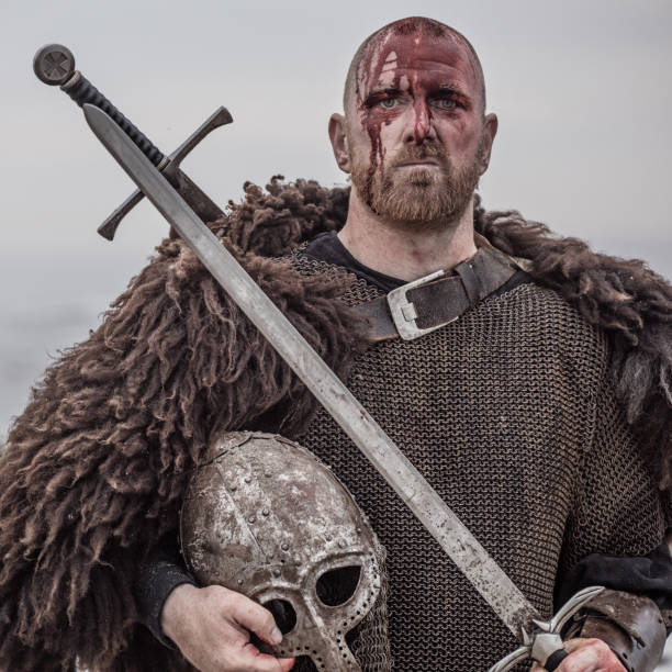 istock Weapon wielding bloody medieval warrior alone on a cold seashore 999123344