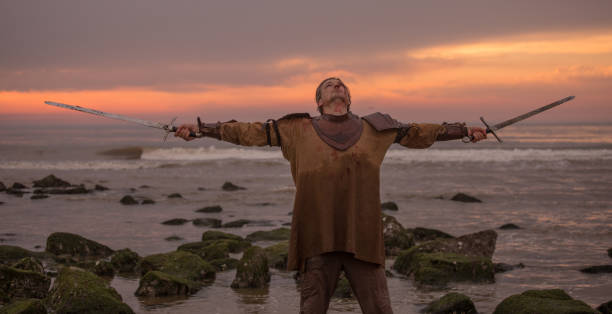 istock Weapon wielding bloody medieval warrior alone on a cold seashore 999124118