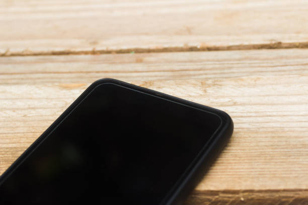 istock close-up of a mobile phone part on Wood board table 999127510