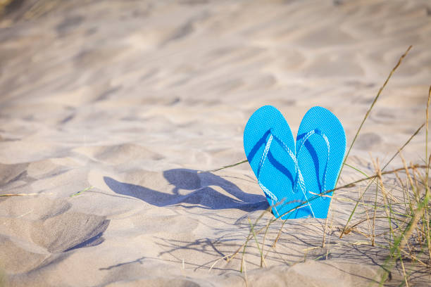 istock Summer, beach or holiday backgrounds: blue flip flops on white sand dune 999128422