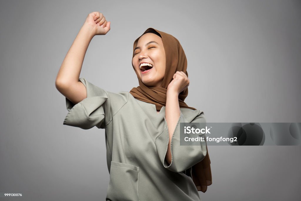 Excited young Muslim woman in white background Women Stock Photo