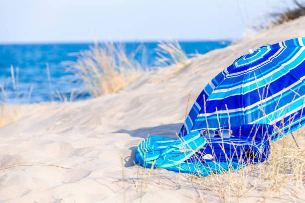 istock Summer, beach or holiday backgrounds: blue beach accessories on white sand dune 999131122