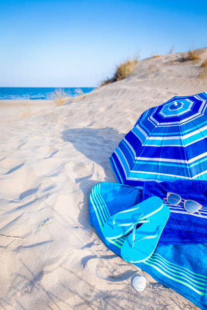 istock Summer, beach or holiday backgrounds: blue beach accessories on white sand dune 999131312