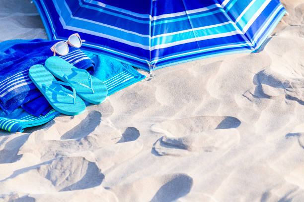istock Summer, beach or holiday backgrounds: blue beach accessories on white sand dune 999131830