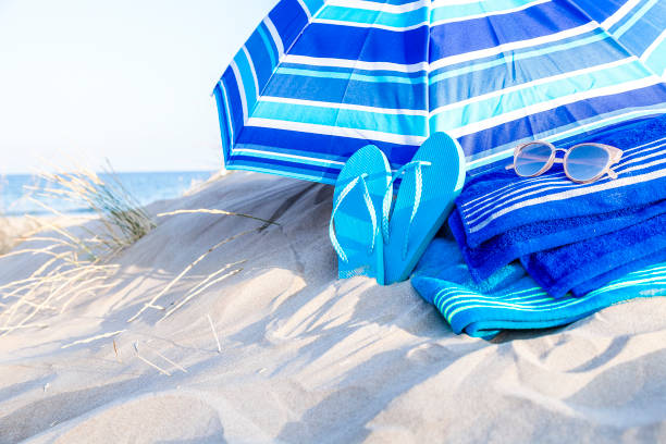 istock Summer, beach or holiday backgrounds: blue beach accessories on white sand dune 999132784