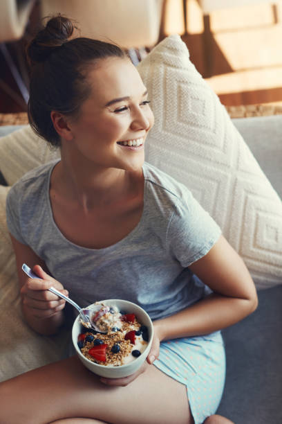 relaxing with a bowl of muesli - eating women breakfast cereal imagens e fotografias de stock