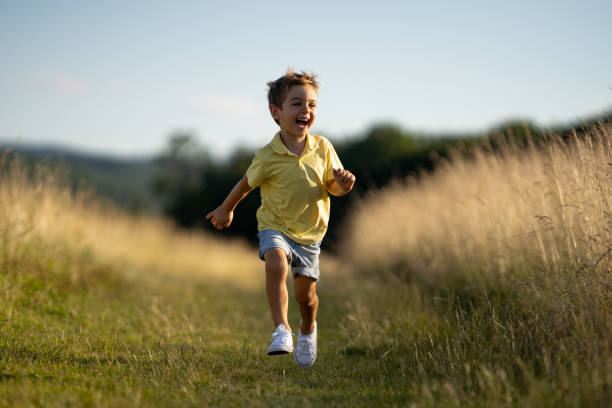 istock happy laughing little boy running on grassland 999140886