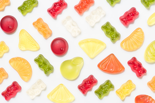 Still life of a variety of candy jars filled with colorful confections.