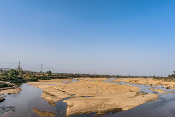 istock Indian river with clean water in sandy bed  with power grid cable laying background. 999164096