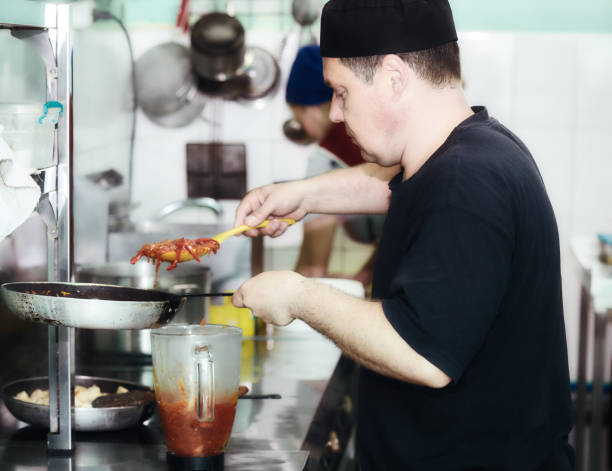 istock Chef in restaurant kitchen at stove with pan 999168326