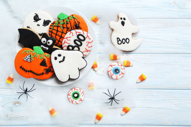 istock Fresh halloween gingerbread cookies on white wooden table 999182898
