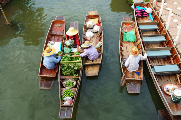 vendeurs de faire des opérations sur le marché pour touriste flottant - damnoen saduak floating market photos et images de collection