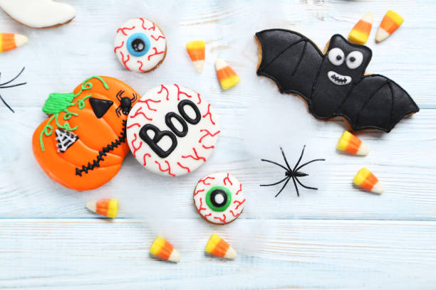 istock Fresh halloween gingerbread cookies on white wooden table 999186852