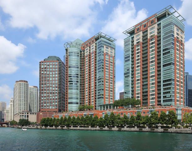 Water view of Chicago Riverwalk lined with rows of condominiums and beautiful landscaping.