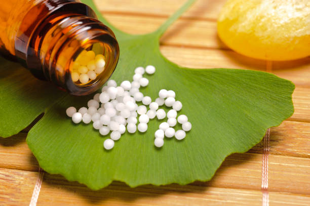 alternative medicine with homeopathic pills on ginkgo leaf - homeopatic medicine imagens e fotografias de stock