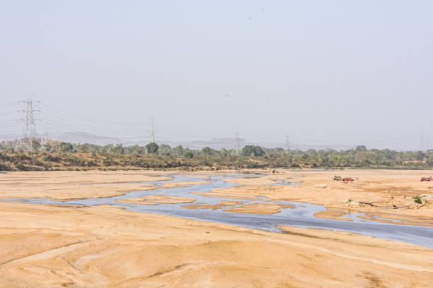 istock Indian river with clean water in sandy bed  with power grid cable laying background. 999206208
