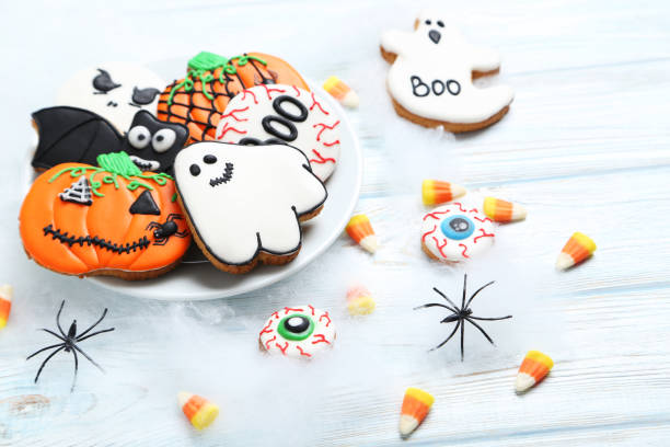 istock Fresh halloween gingerbread cookies on white wooden table 999206666