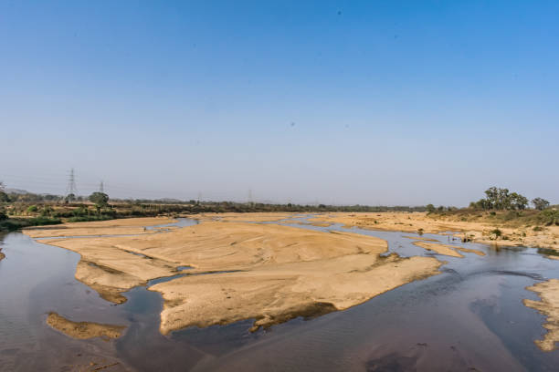 istock Indian river with clean water in sandy bed  with power grid cable laying background. 999207472