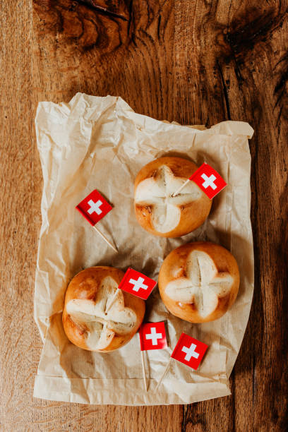 スイスのパンはドイツ語 1 と呼ばれます。8 月 1 日建国記念日を祝うためにスイスの augustweggen 焼き。 赤の背景に白い十字のスイスの国旗。 - cantons ストックフォトと画像