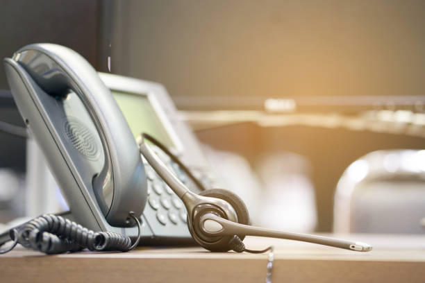 close up soft focus on telephone devices at office desk for customer service support concept