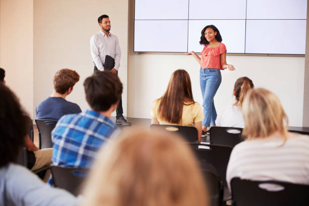 istock Female Student Giving Presentation To High School Class In Front Of Screen 999216804