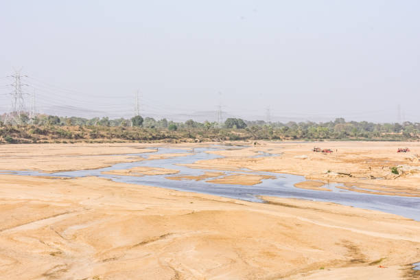 istock Indian river with clean water in sandy bed  with power grid cable laying background. 999217534