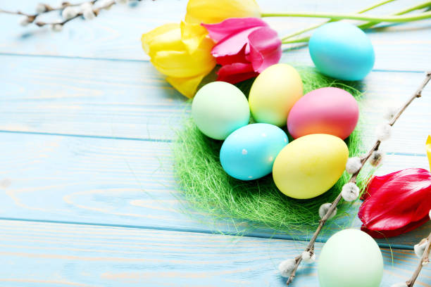 istock Easter eggs in nest on a blue wooden table 999217668