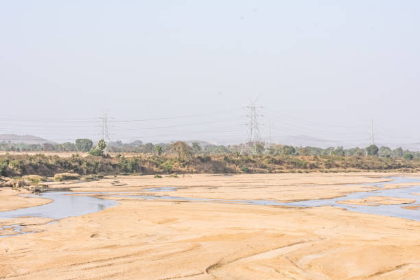 istock Indian river with clean water in sandy bed  with power grid cable laying background. 999218028
