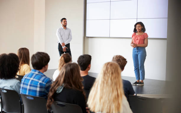 istock Female Student Giving Presentation To High School Class In Front Of Screen 999220938