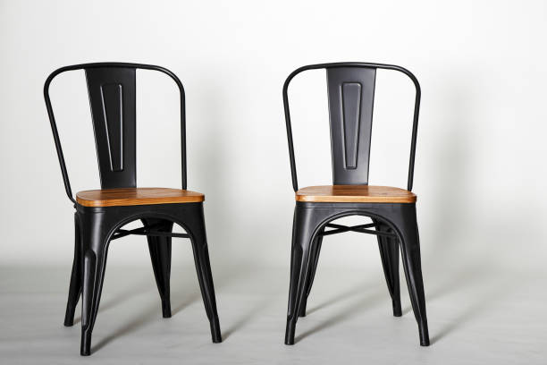 istock Two vintage black chairs on grey background 999222494