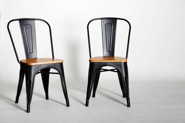 istock Two vintage black chairs on grey background 999222498