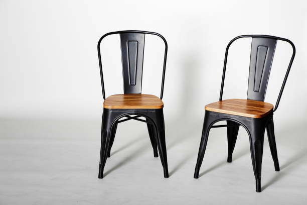 istock Two vintage black chairs on grey background 999222500