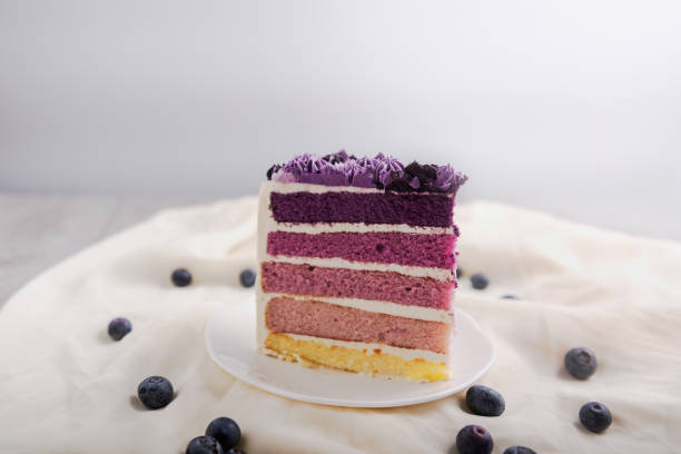 istock Closeup slice blueberry cake on white plate with cream layer and fresh blueberry fruit on isolate background. 999225380