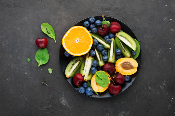 Fruit summer bowl. Orange, kiwi, cherry, spinach, blueberry, apricot plate. Top View