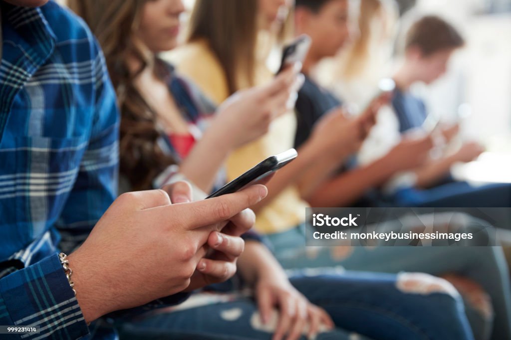 Close Up Of A Line Of High School Students Using Mobile Phones Mobile Phone Stock Photo