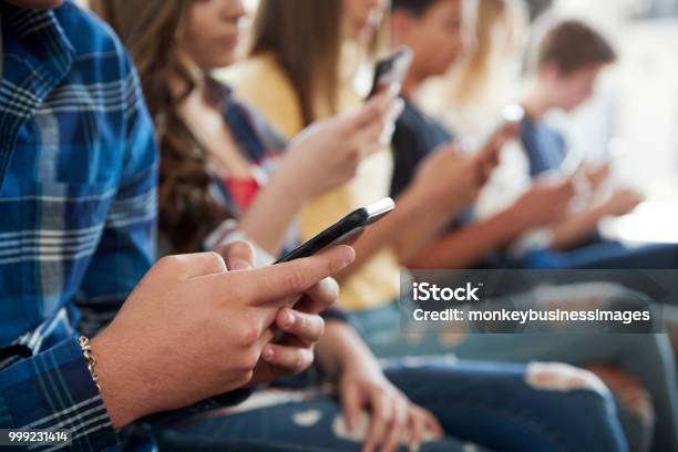 Close Up Of A Line Of High School Students Using Mobile Phones Stock Photo - Download Image Now