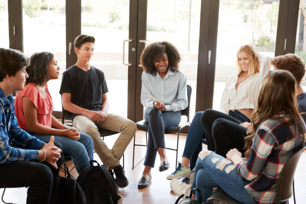 istock Female Tutor Leading Discussion Group Amongst High School Pupils 999231668