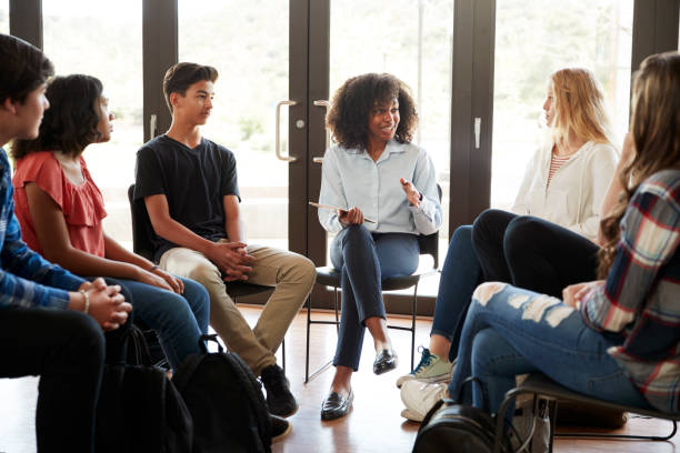 高校生の間で女性教師リード ディスカッション グループ - high school high school student classroom group of people ストックフォトと画像