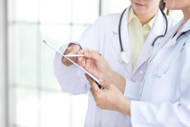 istock two doctor with stethoscope discuss together with patient case study with copy space of clinic and hospital background 999231920