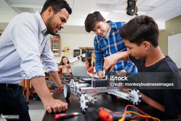 Teacher With Male Pupils Building Robotic Vehicle In Science Lesson Stock Photo - Download Image Now