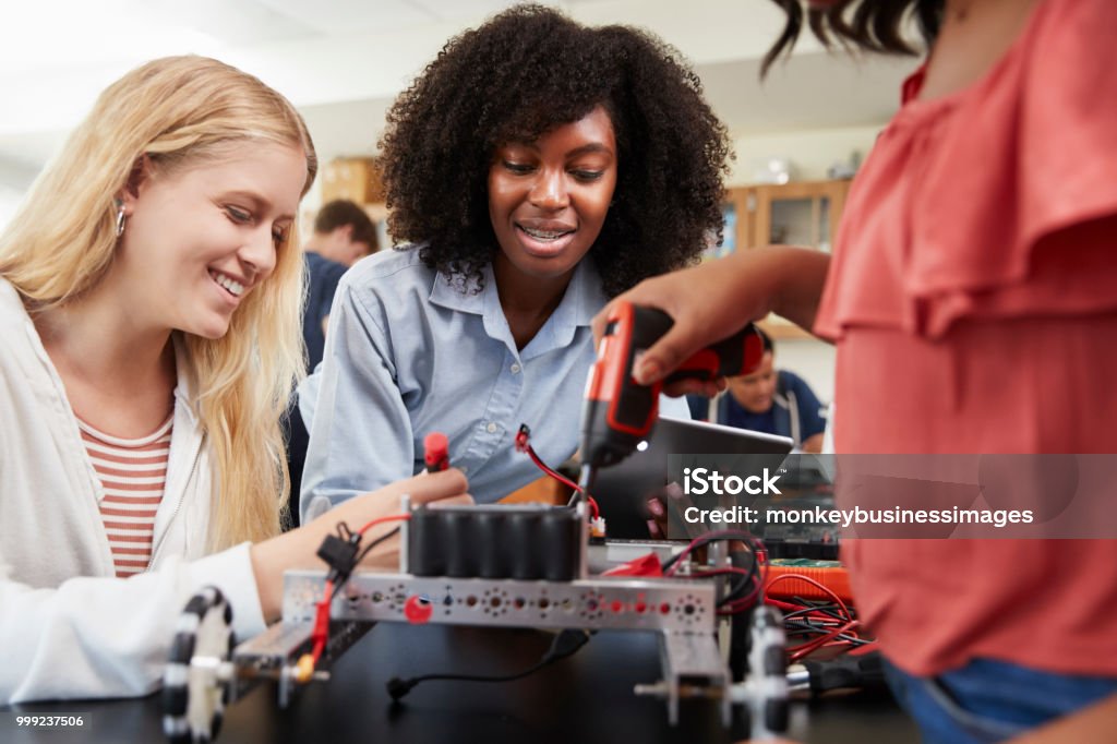 Teacher With Female Pupils Building Robotic Vehicle In Science Lesson Student Stock Photo