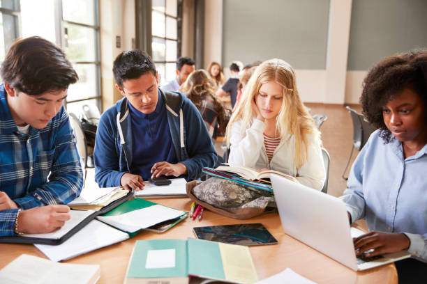 istock High School Students Using Laptops And Digital Tablets Working With Female Teacher At Desk 999246096